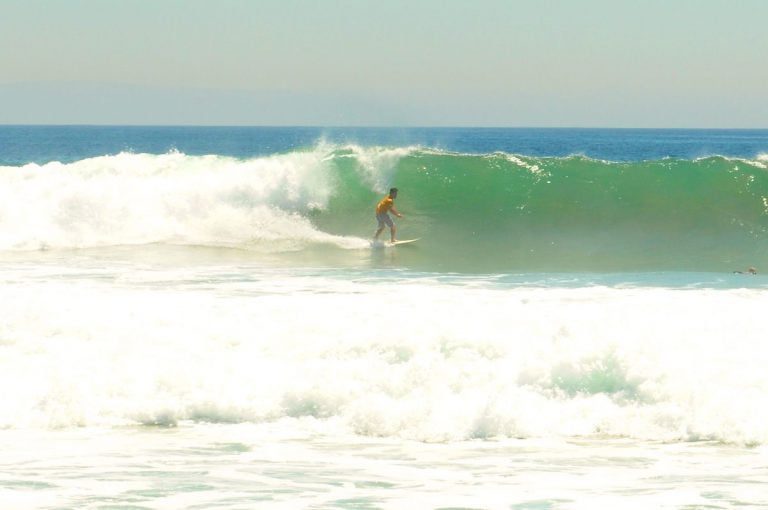 Surfer Riding Waves During High Surf Conditions