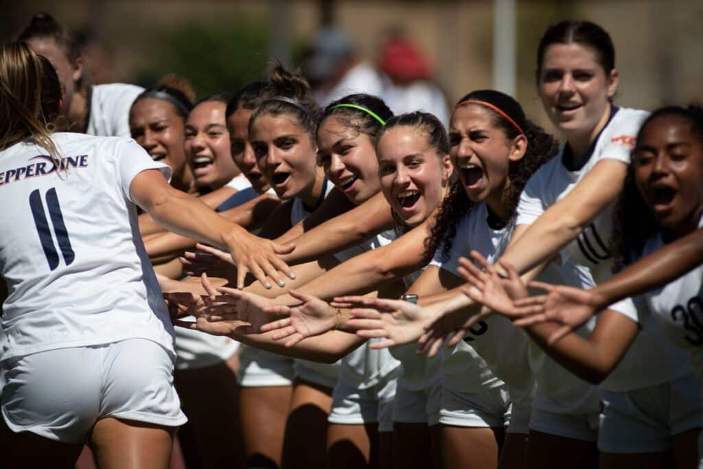 Waves players celebrate in during their scimmage against USC