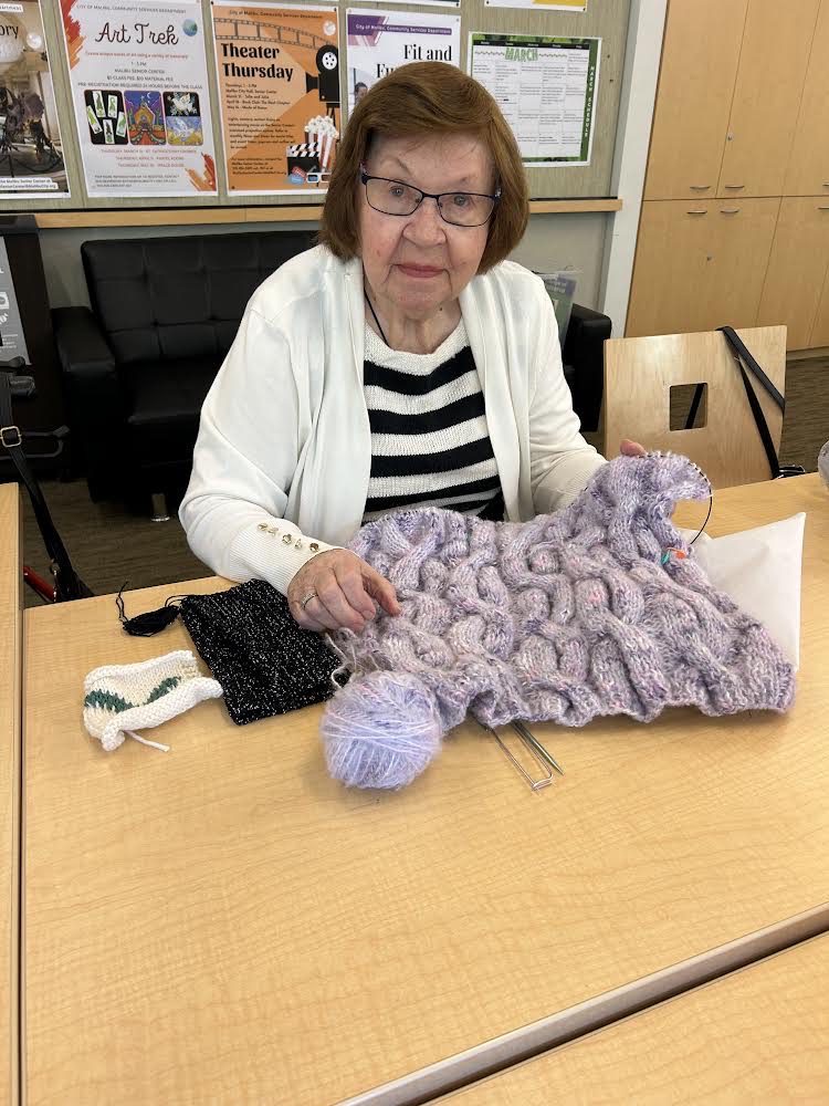 Ninety year old Pina Cianfaglione who once led the knitting group is still knitting complicated cabled garments freehand without a pattern. Photos by Judy AbelTMT