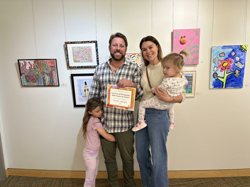The Spiegel family celebrates young Deckers display art piece Love at the Student Art Exhibit closing reception