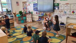 Shari Latta plays the guitar for her young pupils during preschool classes at Our Lady of Malibu. Photos courtesy Lisa Hall of OLM.
