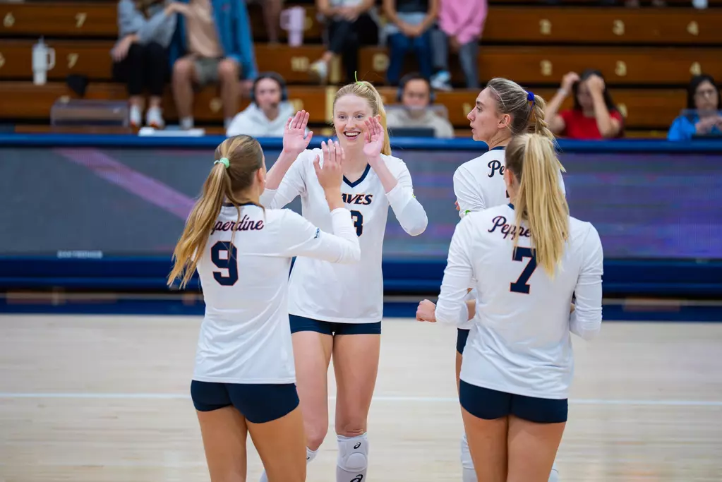 Riley Simpson high fives her teammates. Photo by Kyle Cajero